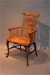 An 18th century yew wood comb back armchair.
